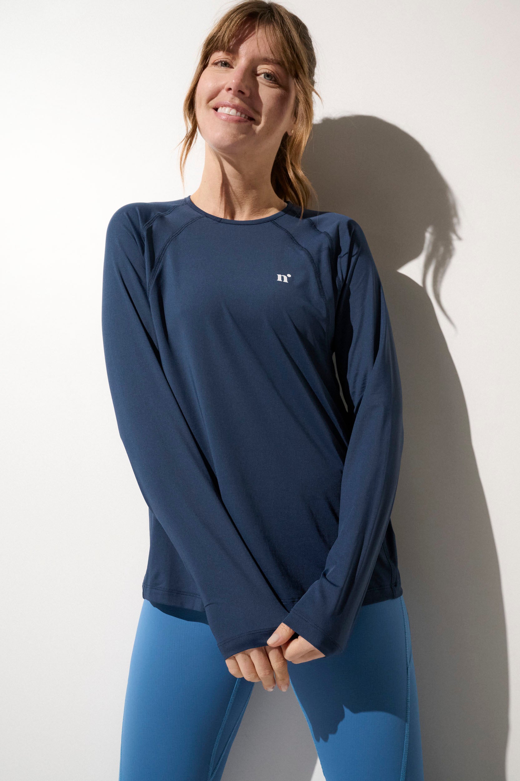 Femme portant un t-shirt anti-UV bleu marine UPF50+, idéal pour le sport et la protection solaire.