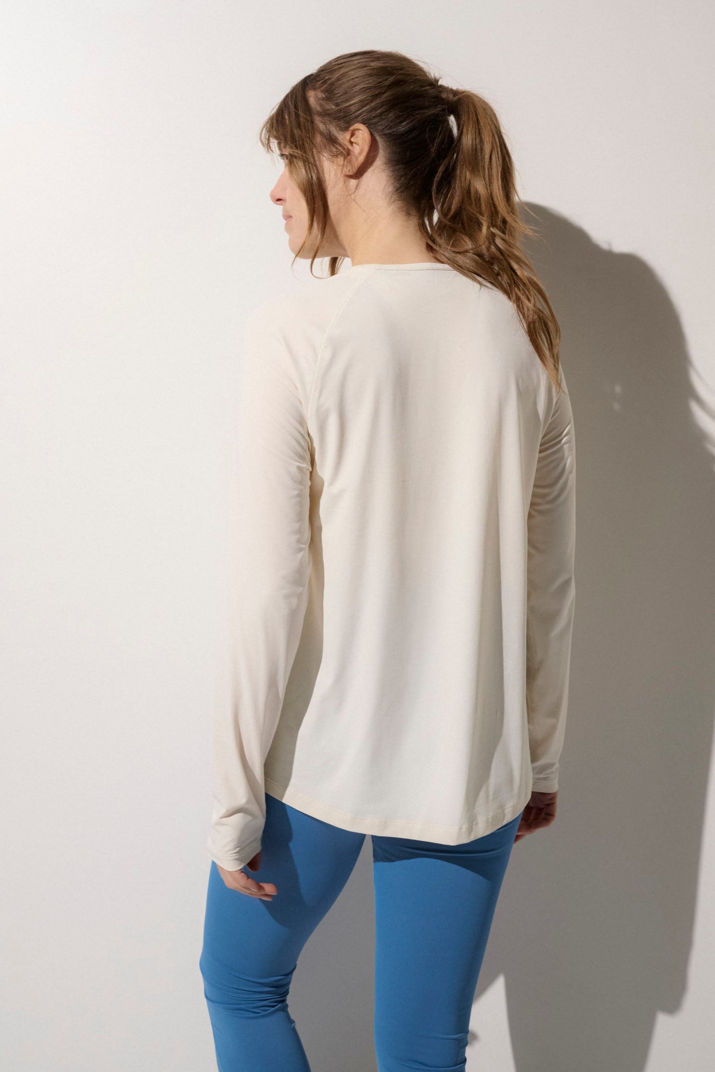 T-shirt anti-UV crème pour femme, manches longues, respirant et UPF50+, idéal pour activités en plein air.