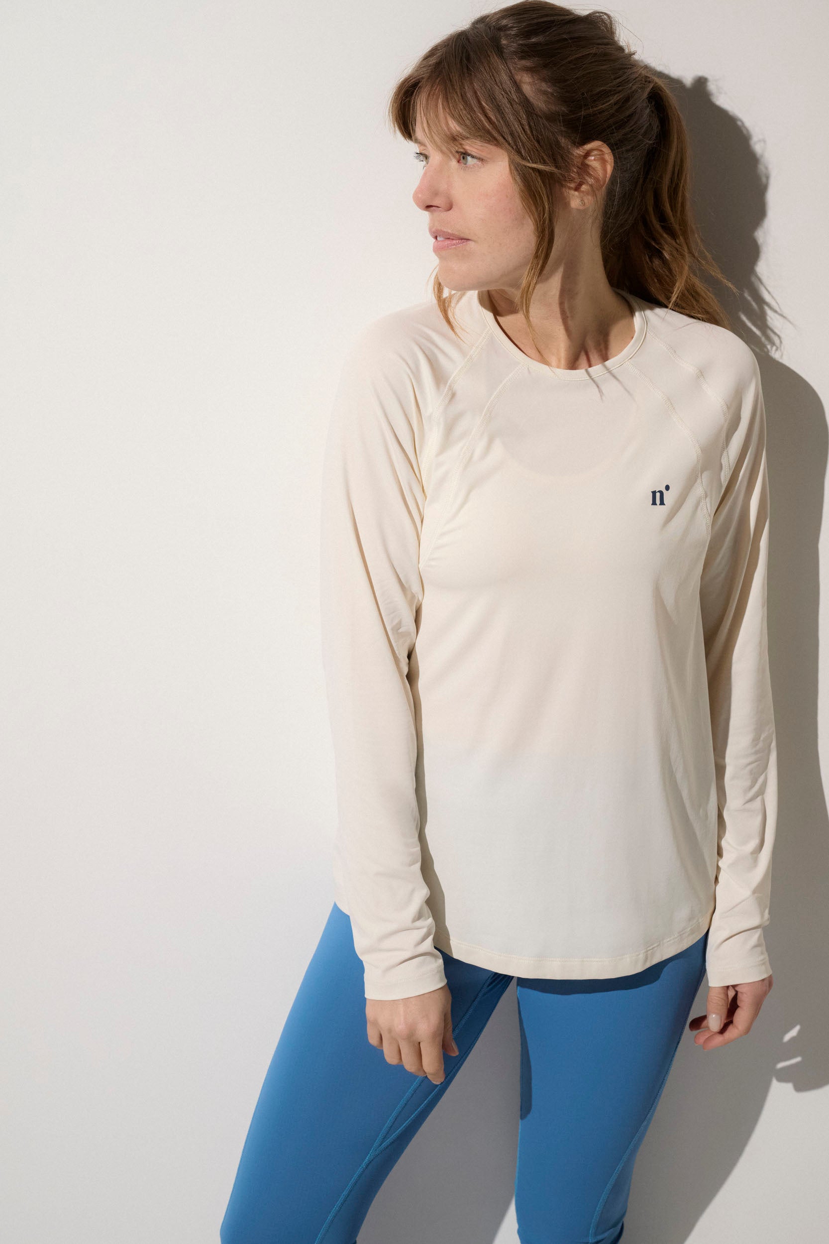 T-shirt anti-UV beige pour femme, manches longues, léger et confortable, UPF50+, idéal pour les activités sportives.