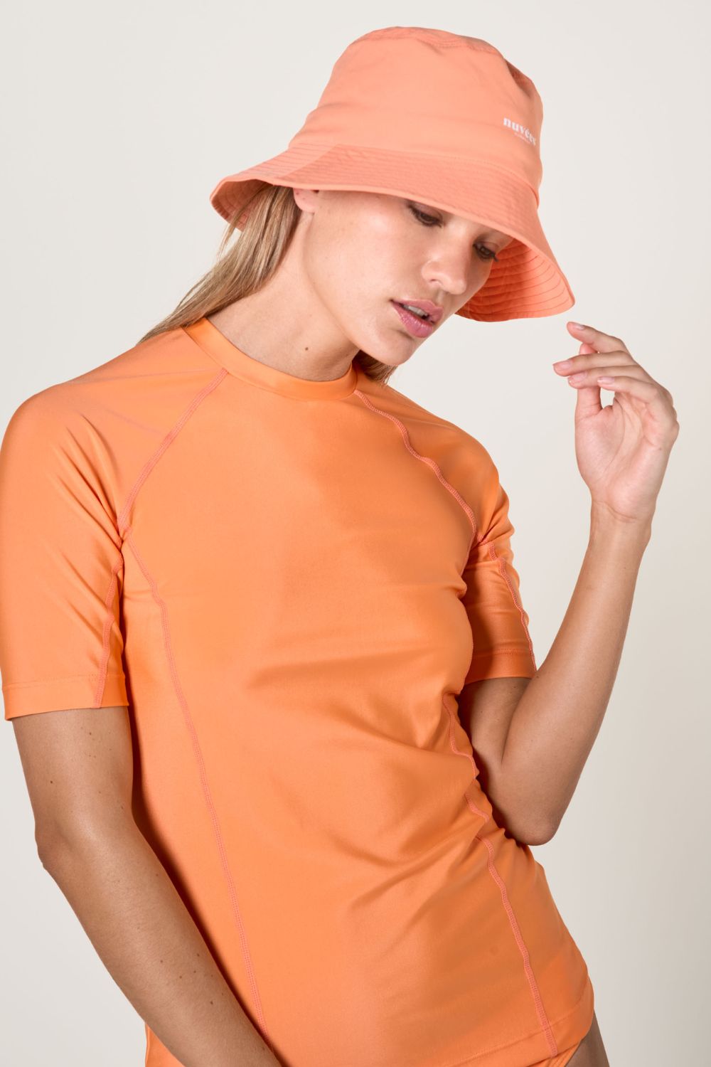 Bob anti-UV sorbet abricot et t-shirt orange, parfaits pour des activités de plein air ensoleillées.