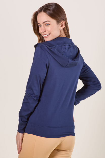 Femme portant un sweat-shirt anti-UV bleu, à capuche, idéal pour protéger du soleil en dehors.